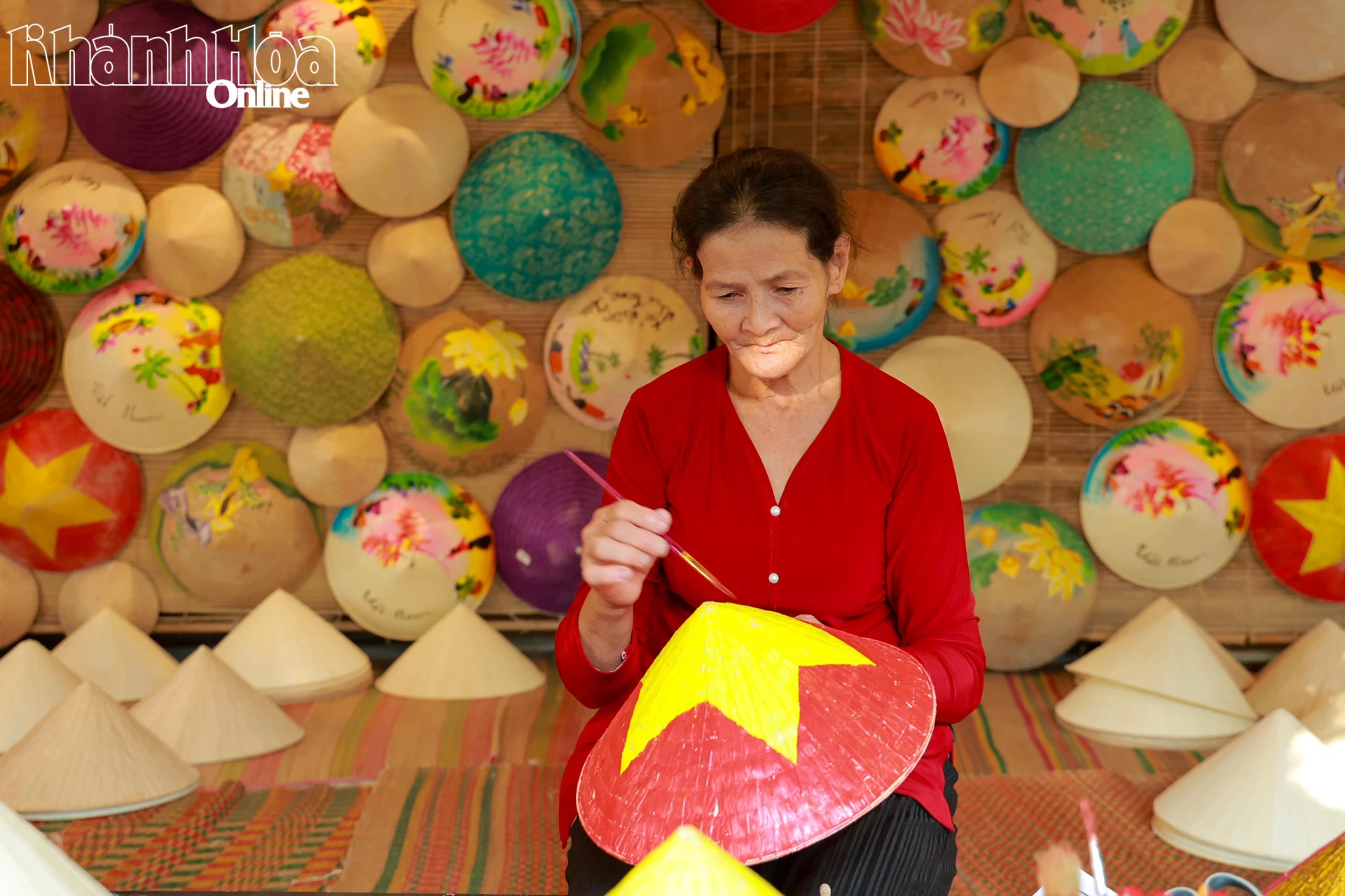 Nghệ nhân đang thao tác trang trí lên những chiếc nón lá.
